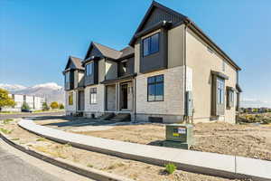 View of front facade featuring stone siding, a mountain view, and entry steps