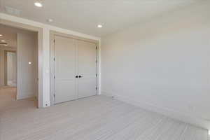 Unfurnished bedroom with recessed lighting, carpet, and a closet