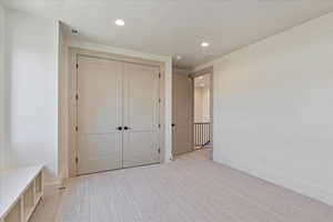 Unfurnished bedroom with recessed lighting, carpet floors, and a closet