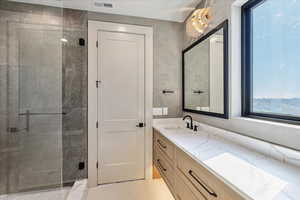 Full bathroom featuring vanity, a stall shower, and light tile patterned floors