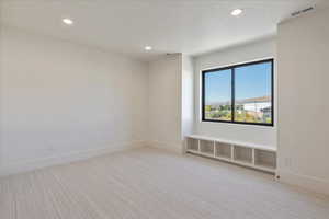 Spare room with recessed lighting and light colored carpet