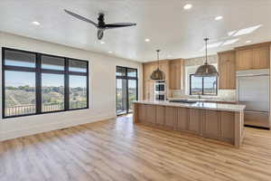 Kitchen featuring appliances with stainless steel finishes, a spacious island, decorative light fixtures, decorative backsplash, and a textured ceiling