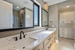 Full bath with double vanity, a shower stall, light tile patterned floors, and recessed lighting
