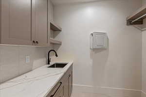 Laundry area featuring a sink and baseboards
