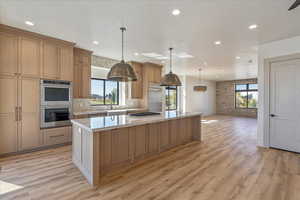 Kitchen with decorative light fixtures, stainless steel appliances, a spacious island, plenty of natural light, and recessed lighting