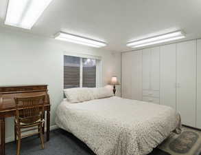 Bedroom featuring a textured ceiling and dark colored carpet