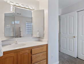 Bathroom featuring vanity and light carpet