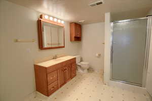 Full bath featuring a stall shower, vanity, and light flooring