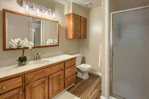 Bathroom with vanity, a stall shower, and light wood-type flooring