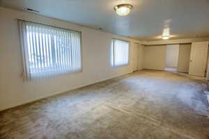Carpeted spare room featuring baseboards