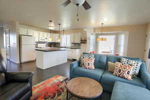Living room with dark wood-type flooring and ceiling fan