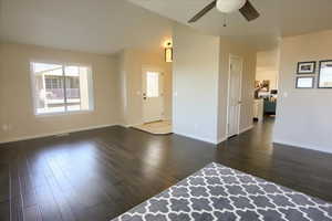 Unfurnished living room with dark wood-style flooring and a ceiling fan