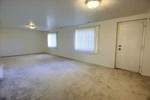 Empty room featuring light carpet and baseboards
