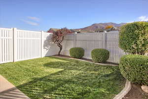 Fenced backyard featuring a mountain view