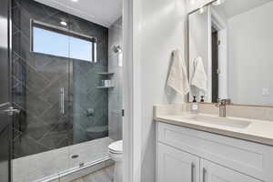 Full bath featuring vanity and a marble finish shower