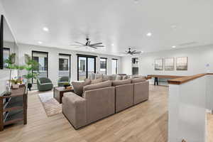 Living room featuring a ceiling fan, recessed lighting, and light wood finished floors