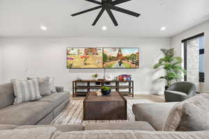 Living room with wood finished floors, recessed lighting, and a ceiling fan