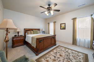 Bedroom with light colored carpet and ceiling fan