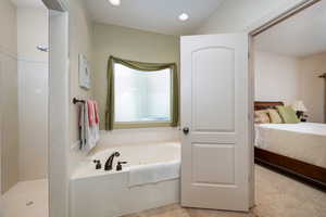 Ensuite bathroom featuring a garden tub, a walk in shower, and recessed lighting