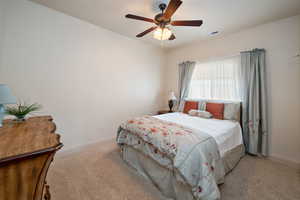 Bedroom featuring ceiling fan and light carpet
