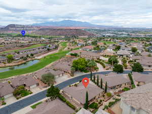 Aerial view of residential area featuring a golf course and a water and mountain view