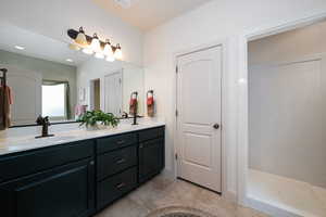 Bathroom featuring double vanity, walk in shower, light tile patterned floors, and recessed lighting