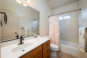 Bathroom featuring vanity, shower / bath combination with curtain, and light tile patterned flooring