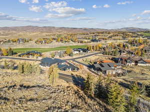 Aerial overview of property's location with a mountain backdrop and nearby suburban area