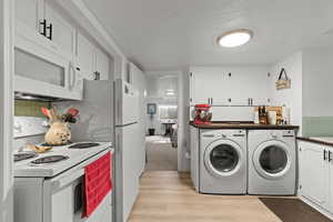 Laundry area with light wood-style floors and a textured ceiling