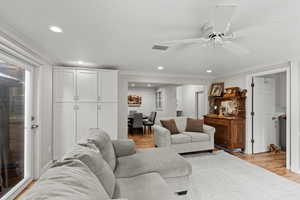 Living area featuring recessed lighting, light wood finished floors, ceiling fan, and crown molding