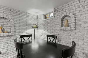 Dining room featuring brick wall