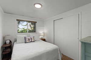 Bedroom featuring a closet, carpet floors, and wood walls