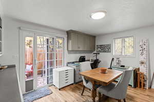 Office area with light wood-type flooring and a textured ceiling
