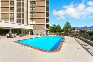Community pool with a mountain view and a patio area.