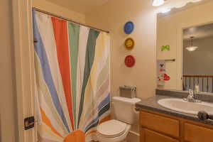 Bathroom featuring a shower with curtain and vanity
