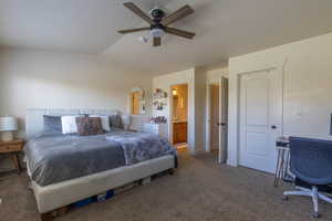 Bedroom featuring carpet flooring, vaulted ceiling, connected bathroom, and a ceiling fan