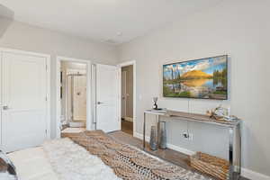 Bedroom featuring wood finished floors and connected bathroom