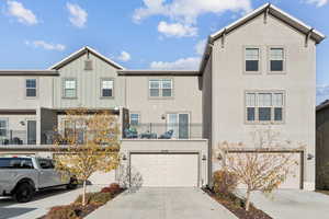 View of front of home featuring driveway, stucco siding, board and batten siding, and an attached garage