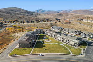 Aerial view of property and surrounding area featuring nearby suburban area and a mountain backdrop