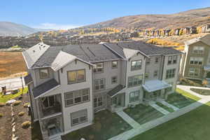 Rear view of house with a residential view, a mountain view, and roof with shingles