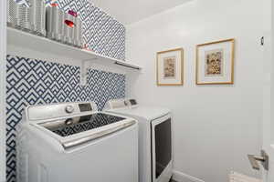 Laundry room with washer and clothes dryer and baseboards
