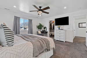 Bedroom featuring dark colored carpet, a ceiling fan, recessed lighting, and a walk in closet