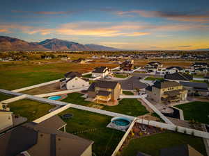 Aerial view at dusk of a residential view, view of pool, and a mountain view