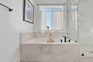 Bathroom featuring a bath and a shower stall