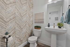 Bathroom with toilet and wood finished floors
