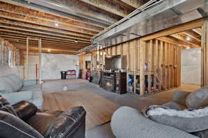 Living area featuring unfinished concrete floors and a lit fireplace