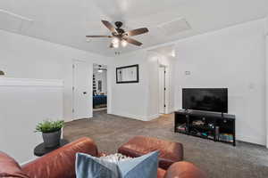 Living area featuring carpet floors and ceiling fan