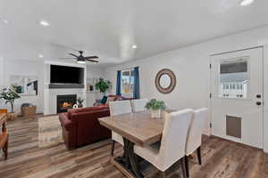 Dining space with recessed lighting, dark wood finished floors, ceiling fan, a glass covered fireplace, and a textured ceiling