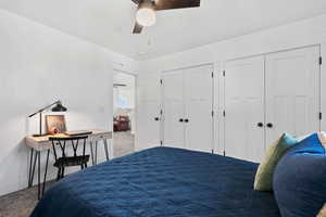 Carpeted bedroom with a closet and a ceiling fan