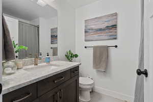 Bathroom with vanity, light tile patterned floors, and a shower with shower curtain